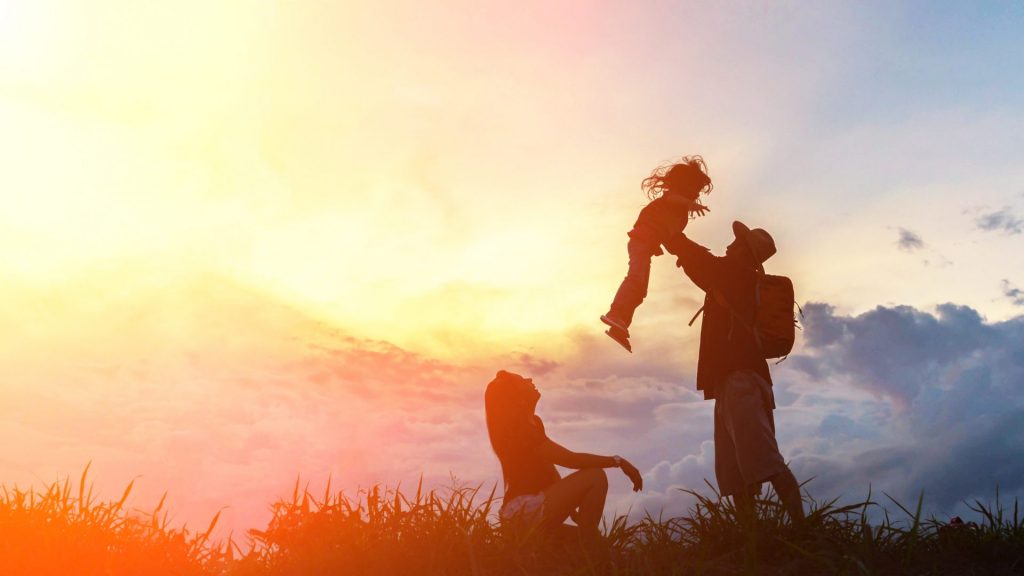 the-happy-family-of-three-people-mother-father-and-child-in-front-of-sunset-sky