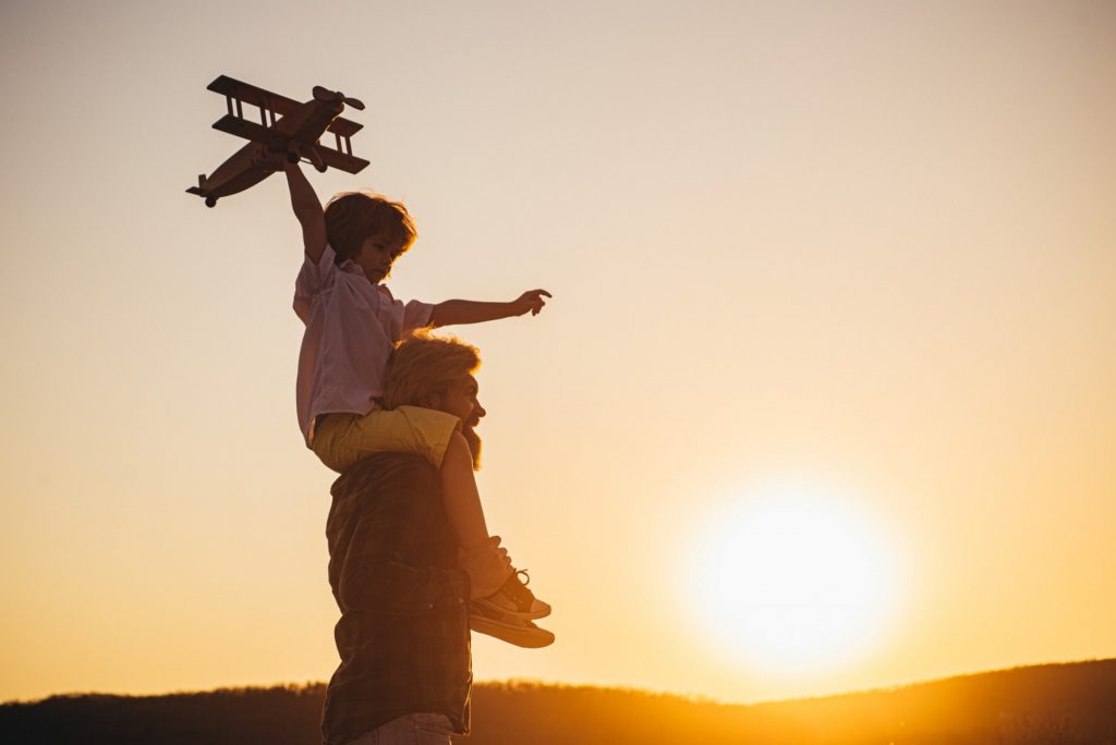 sunset-silhouette-happy-father-child-son-with-airplane-dreams-traveling-father-carrying-his-son-shoulders